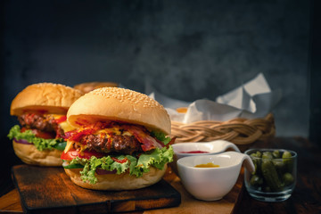 Delicious 2 home made hamburger with beef, ketchup, mustard and fresh vegetables served on wooden board. Free space for text