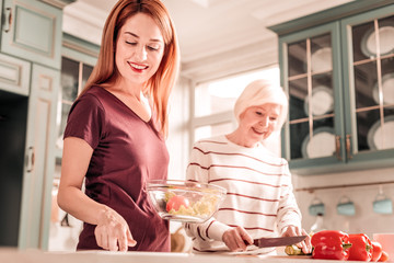 Beautiful female person helping her mom in kitchen