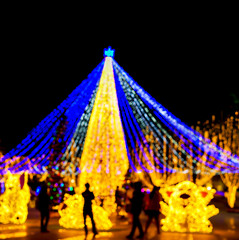 Wall Mural - Blurred and bokeh of Christmas holiday lighting with Silhouette of people in night time background.