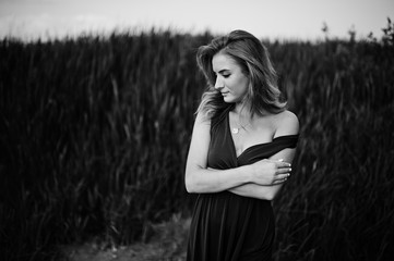 Wall Mural - Blonde sensual woman in red marsala dress posing in the reeds.