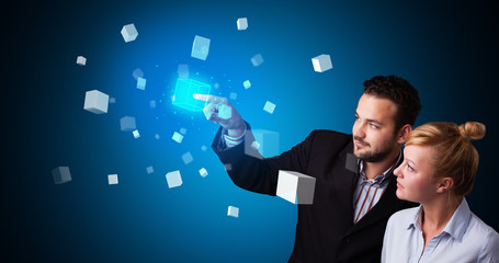 Poster - Man and woman touching hologram screen displaying cube symbols

