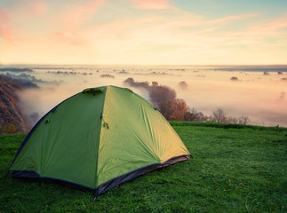 Wall Mural - green tent on hill above misty river