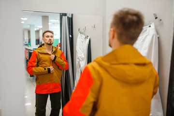 Wall Mural - Man trying on a jacket for ski or snowboarding