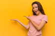 © Asier - Young european woman isolated over yellow background excited holding a copy space on palm.