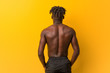 © Asier - Young black man shirtless wearing swimsuit from behind, looking back.