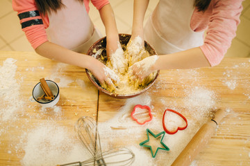 Two little girls chefs crumple the dough