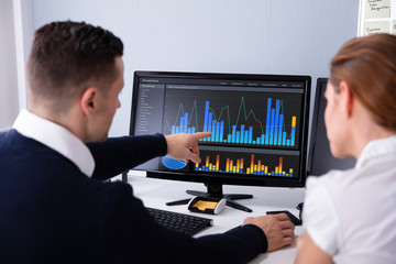 Poster - Two Businesspeople Examining Graph On Computer