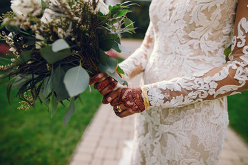 Wall Mural - Beautiful bride in a white dress. Woman with flowers. Lady with mehendi on her hands