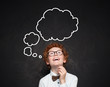 © millaf - Happy smart kid with empty speech clouds bubbles at the classroom blackboard. Education and school concept. Student boy portrait