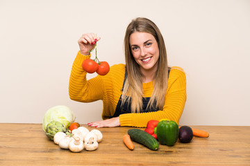 Happy blonde woman with lots of vegetables