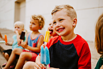 Group of Kids Eating Frozen Colorful Popsicles in the Summer