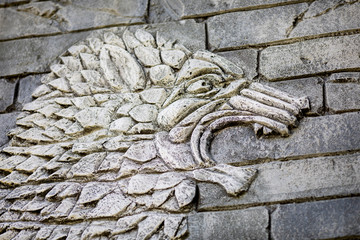 Ancient monster carved in stone on the wall, old decorative ornament