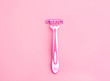 Body Depilation Disposable razor pink on a pink background. Selective focus.