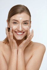 Wall Mural - Skin care. Woman applying facial cream on beauty face closeup