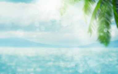 blurred summer natural marine tropical blue background with palm leaves and sunbeams of light. sea a
