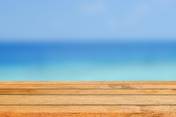 abstract blur sea ocean with wood floor perspective for summer season travel banner concept