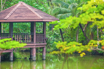 Poster - Brown wooden gazebo in a pool garden.