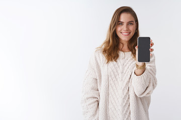 Wall Mural - Girl wanna hear your opinion showing you smartphone display. Attractive charming friendly-looking woman extending hand holding mobile phone sharing funny picture smiling broadly white background