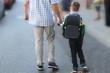 man leads the boy by the hand in elementary school, first-grader, first school day, the concept is back to school