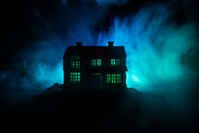 Old House With A Ghost In The Forest At Night Or Abandoned Haunted Horror House In Fog. Old Mystic Building In Dead Tree Forest. Trees At Night With Moon. Surreal Lights.