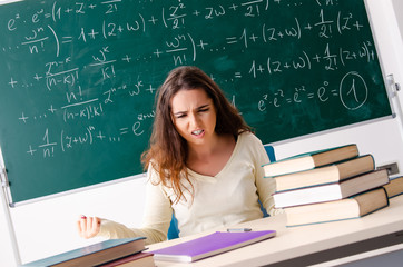 young female math teacher in front of chalkboard