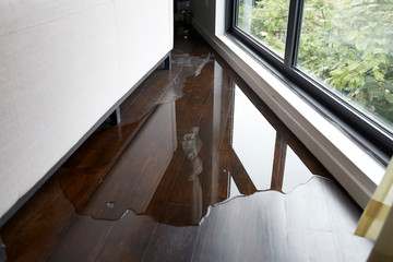 water leaking and flooded on wood parquet floor. room floor will damage after the water flooded.