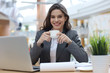 © ty - Attractive smiling businesswoman sitting in the office with a cup of coffee.