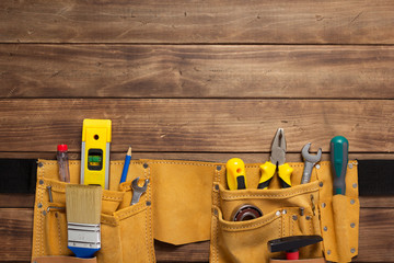 instruments in tool belt at wooden table