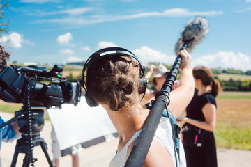 Woman holding microphone on a boom during video production