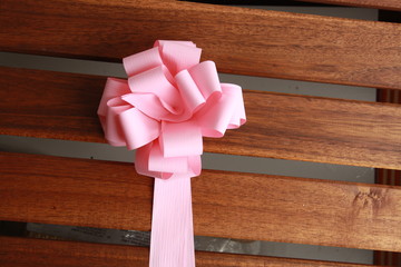 pink gift tie on wooden background