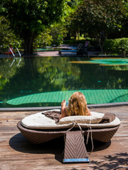 Wall Mural - Beautiful woman relaxing by poolside