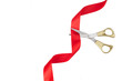 Grand opening. Top view of gold scissors cutting red ribbon on wite background.
