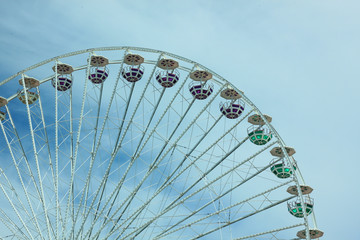 Multicolour ferris wheel on blue sky background. Copy space, street photography.