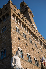 Wall Mural - Florence, Italy - April 15, 2019: View of Neptune statue n the foreground and Palazzo vecchio in the background