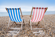 Deckchairs On Beach, Typical English Seaside Holiday Scene, Red And Blue Stripes Representing Main Political Party Of Labour Or Conservative
