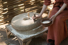 Woman Grinds Wheat And Makes Flour On Millstone