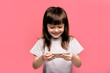 © Marharyta Hanhalo - Side view portrait of her she nice attractive lovely cheerful cheery straight-haired little girl holding in hands device web surfing copy space isolated over light pink studio background