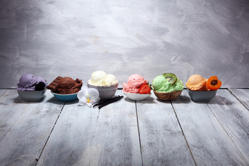 Sticker - ice cream scoops of different colors and flavours with berries, nuts and fruits decoration on white background