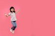 © Marharyta Hanhalo - Little funny child girl jumping on a colored pink background. Happy and joyful, dancing and smiling, enjoy moment. Having fun