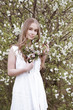 © Iveta - Young woman in white linen dress stay in garden and holding bouquet of flowers