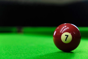 Close-up photos of billiard ball, number 7 and green floor