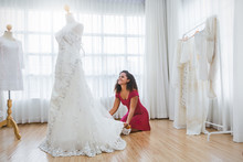 Portrait Of Bride Preparing For The Wedding. African American Woman Dealer Consultant Designer In The Background Of Wedding Dresses Studio. Happiness Success Dream Come True Concept