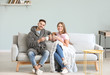 © Pixel-Shot - Happy young couple resting together on sofa at home