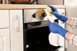 © Pixel-Shot - Man cleaning oven at home