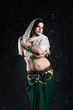 © staras - Sexy women performs belly dance in ethnic dress on black background, abstract art photography
