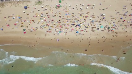 Wall Mural - Crowded public beach with colourful umbrellas,  Aerial footage.