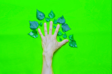 Corporate environmental responsibility concept: Human Hand with leaves in the form of a tree on a green background.