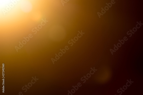 Photographie Lens flare and light beam on dark background yellow color, photo from lens camer