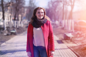 Wall Mural - Pretty girl on a walk in red coat in the city