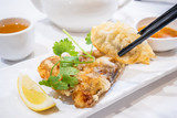 Fototapeta Mapy - Delicious dim sum, famous cantonese food in asia - Fried fish and dumplings with lemon, sauce and tea in hong kong yumcha restaurant, close up
